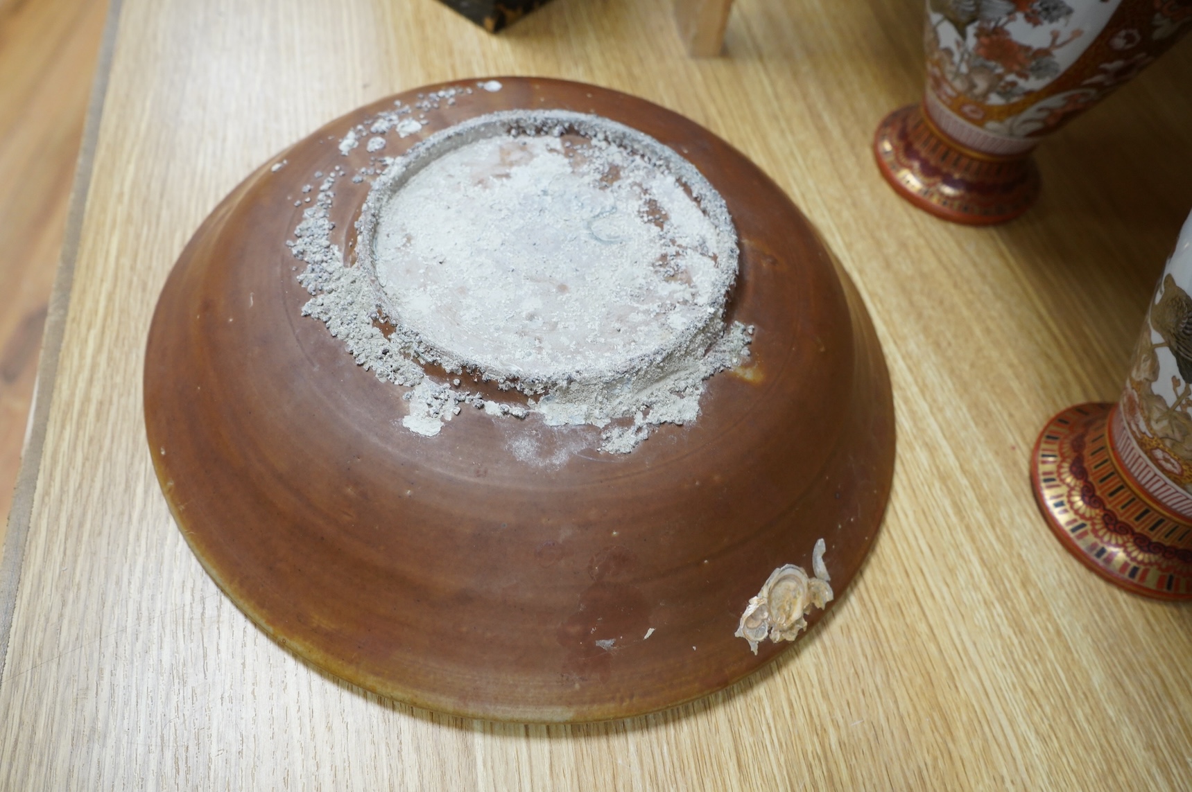 A Chinese late Ming iron brown glazed 'dragon & lion' dish, from a shipwreck, 35cm